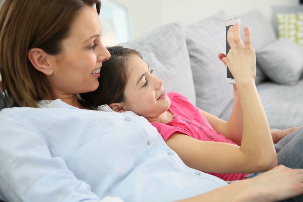 Mother and daughter playing with smartphone